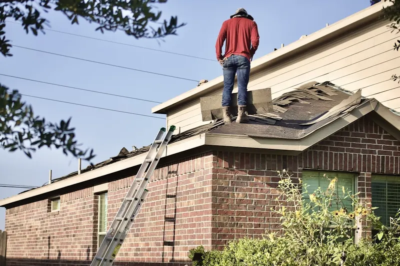 Professional roofer working on a residential roof in Candia
